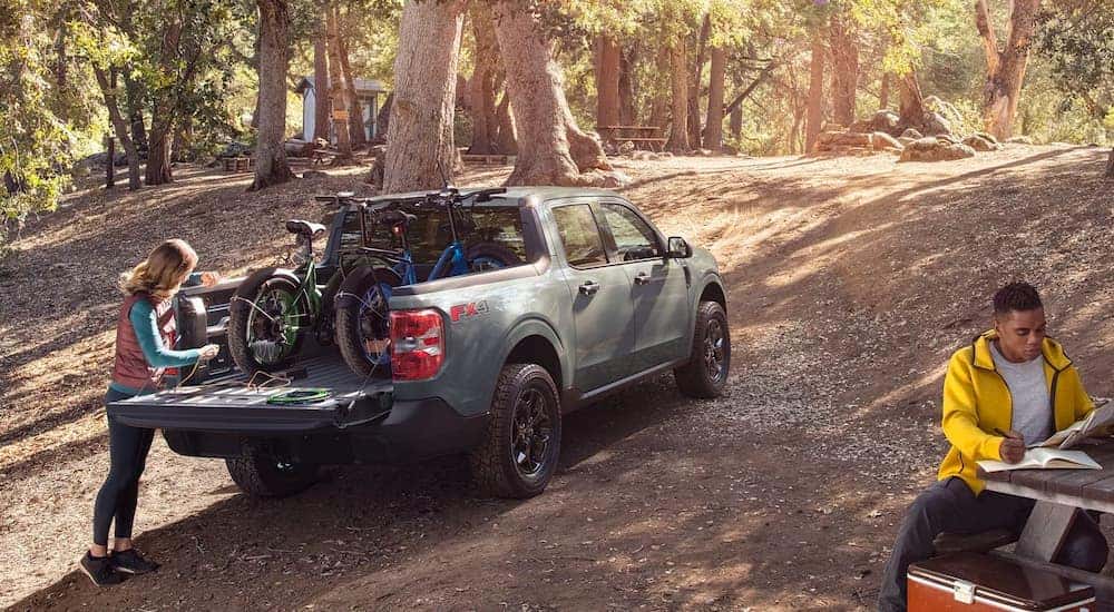 A pale green 2022 Ford Maverick is shown at a campsite with bikes in the bed after visiting a NY Ford Maverick dealer.
