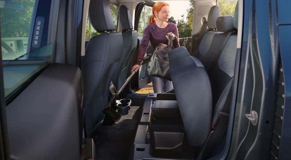 A woman is shown loading hockey equipment into a 2022 Ford Maverick.