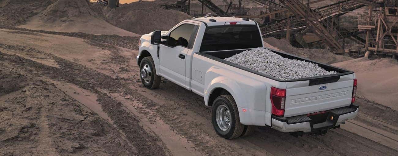 A white 2022 Ford Super Duty is using the bed to transport crushed stone.