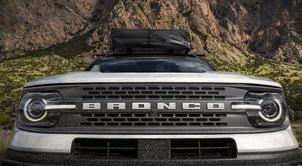 The front grille of a silver 2021 Ford Bronco Sport shows the Bronco logo.
