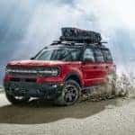 A red 2021 Ford Bronco Sport ids shown off-roading in a desert after leaving a Ford Bronco Sport dealer.