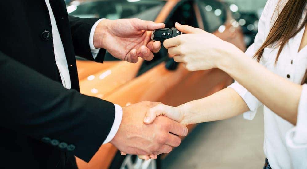 A salesman is shaking hands with a person after a returned Ford Lease in Albany NY.