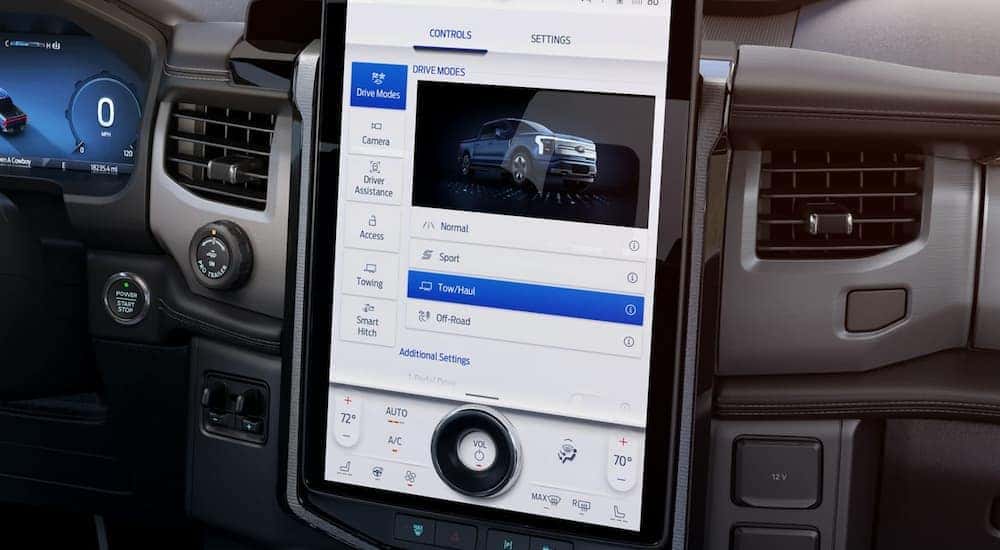 The black interior of a 2022 Ford F-150 Lighting shows the infotainment screen.
