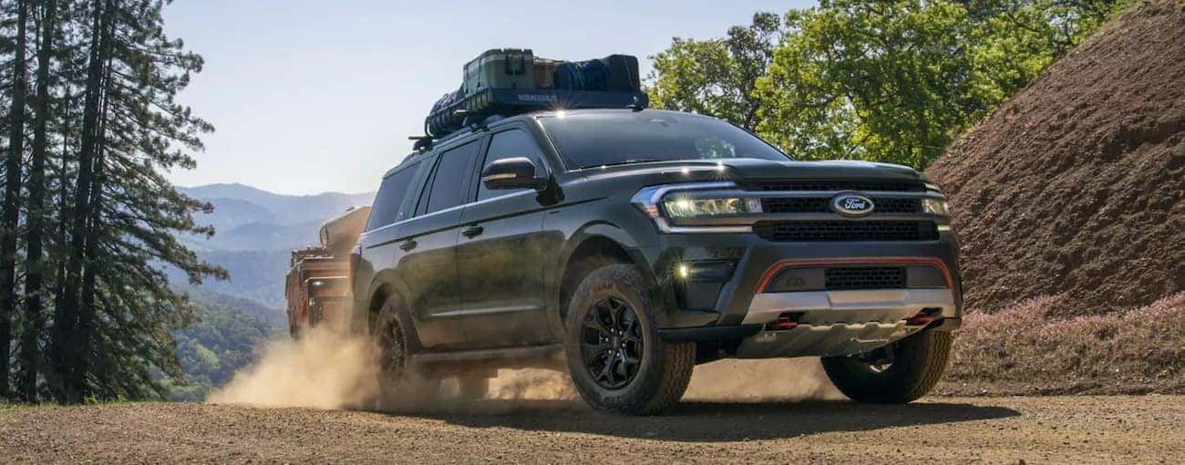 A green 2022 Ford Expedition is shown from the front driving on a dirt road.