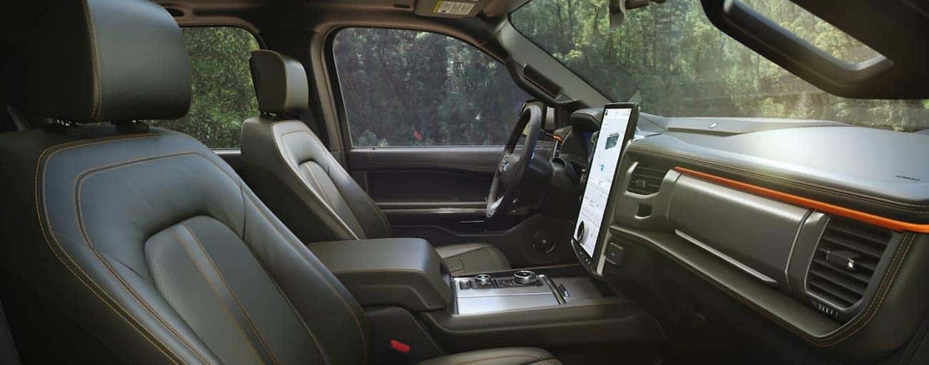 The black interior of a 2022 Ford Expedition shows the front seats and steering wheel.