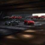 Red and gray 2019 Mazda vehicles parked in a parking garage with the sun shining in the background