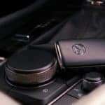 black Mazda SUV key fob with chrome accents on the black console of a Mazda SUV