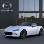 white 2024 Mazda MX-5 Miata in white in front of a mazda dealership