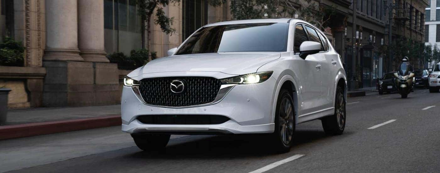 White 2025 Mazda CX-5 driving through a city