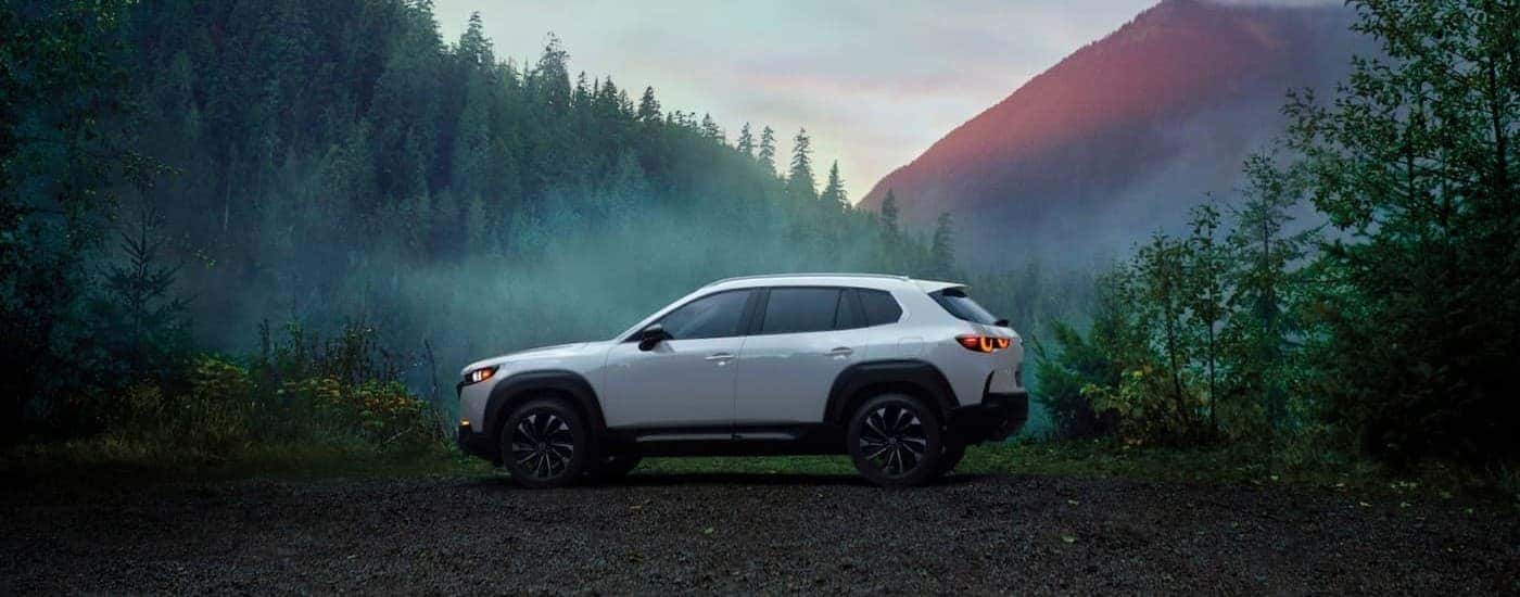 A white 2026 Mazda CX-50 parked near a forest.