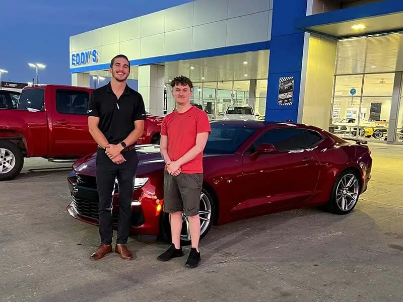 people standing in front of car