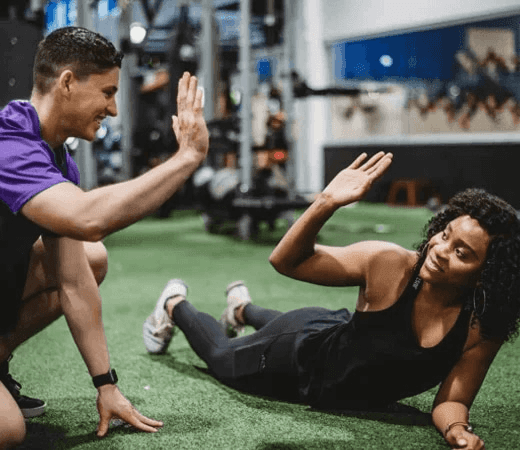 Two People High-Fiving at Gym