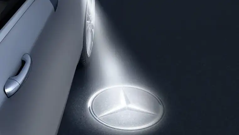 Mercedes-Benz star projected onto the pavement from beneath a side mirror