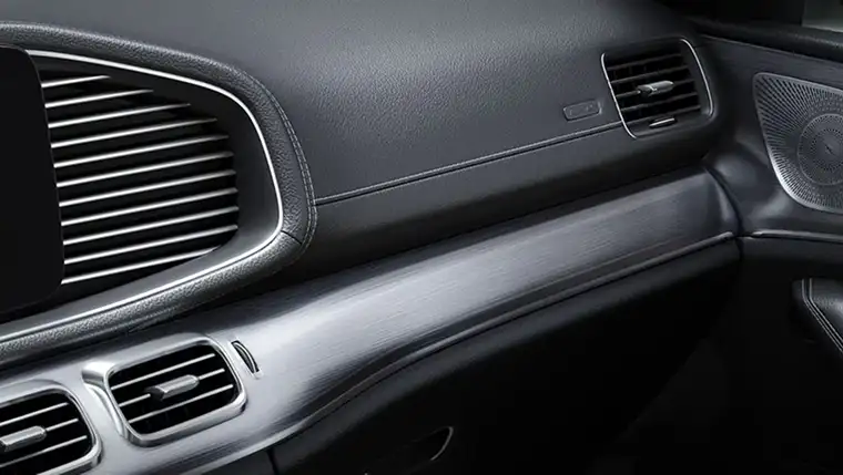 Dashboard air vents set into a horizontally brushed aluminum trim panel