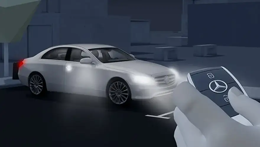 Mercedes-Benz Star projected onto the pavement beside the car at night.