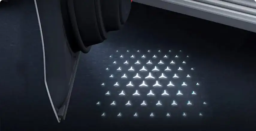 Star pattern projected onto the ground beside the open door of the C-Class.