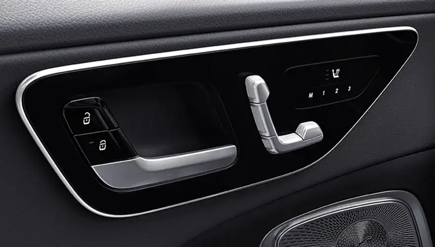 Seat-shaped power seat controls and memory buttons on the C-Class door panel.