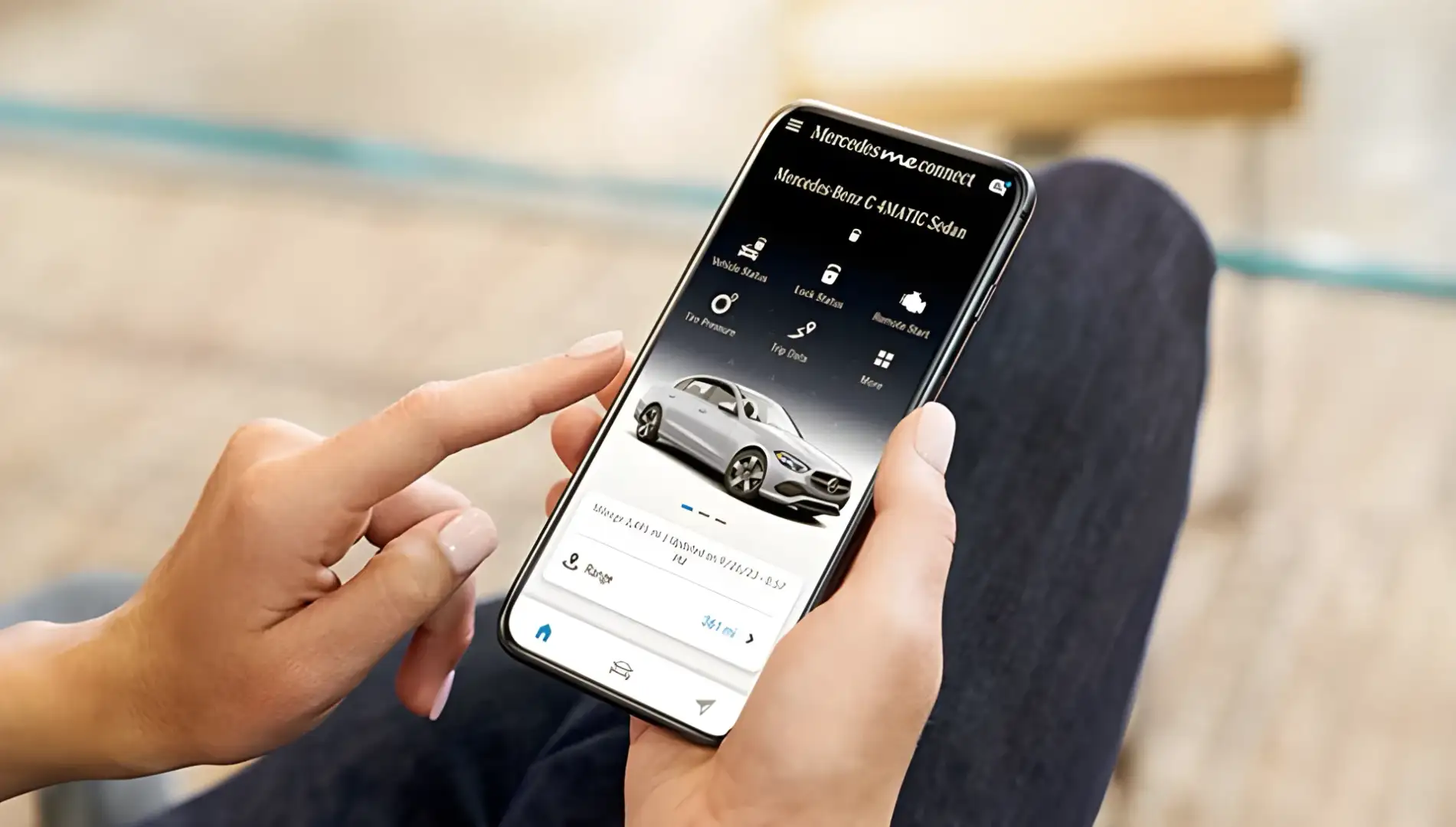 Hand holding a phone showing the Mercedes-Benz app with the vehicle ready to start remotely.