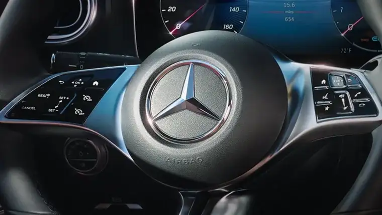 Leather steering wheel with matte silver spoke trim and the Three-Pointed Star hub.