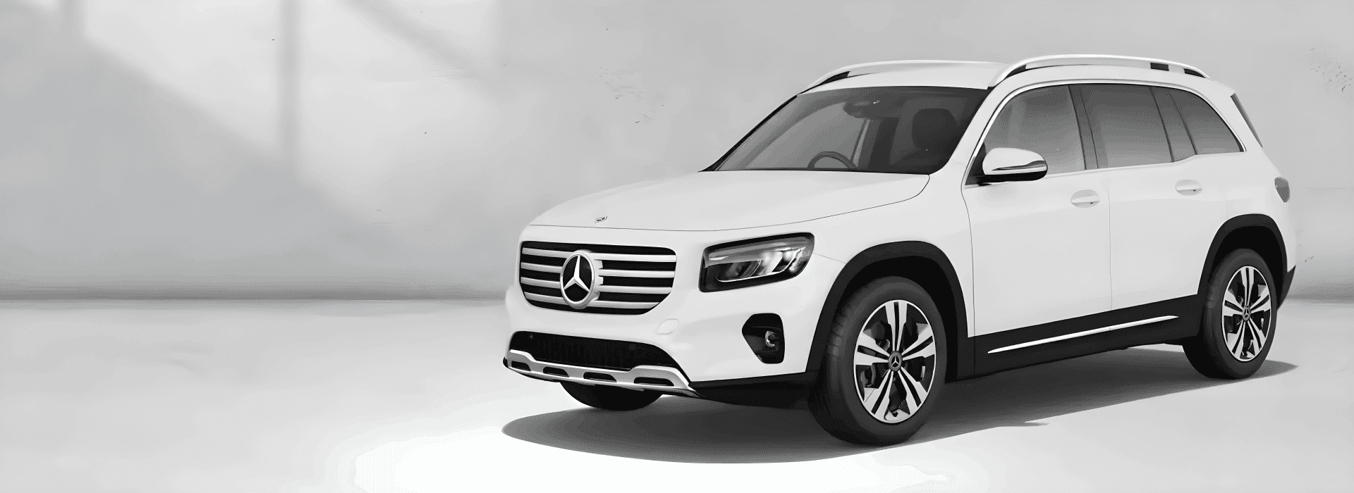 White 2026 Mercedes-Benz GLB 250 4MATIC SUV shown from a front three-quarter angle on a pale grey backdrop.