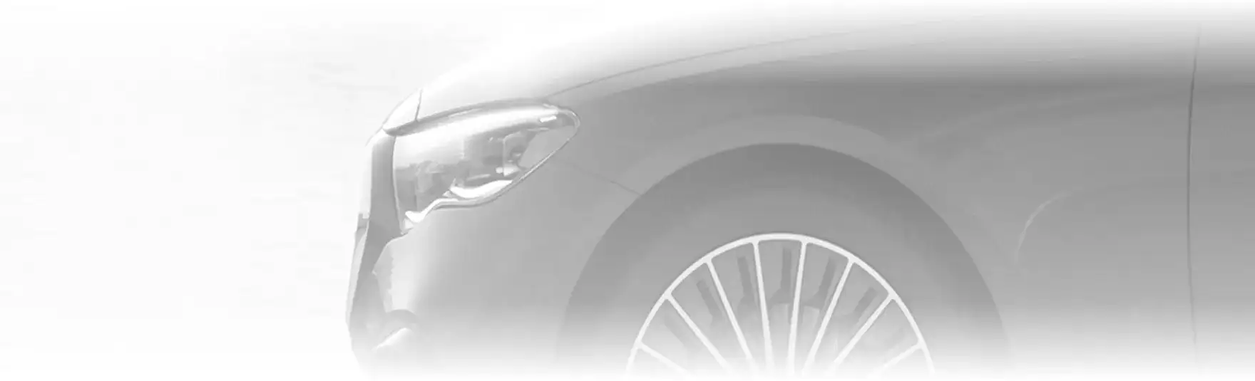 Black-and-white close-up of a GLE headlamp and front wheel.