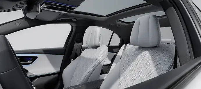 Front seats of the E-Class in white diamond-quilted upholstery beneath the panorama roof.