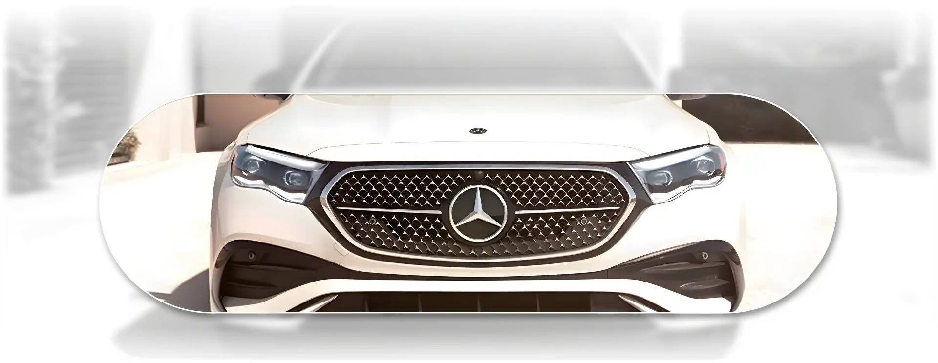 Close crop of the illuminated Star-pattern grille and LED headlamps on a white E 350 4MATIC Sedan.