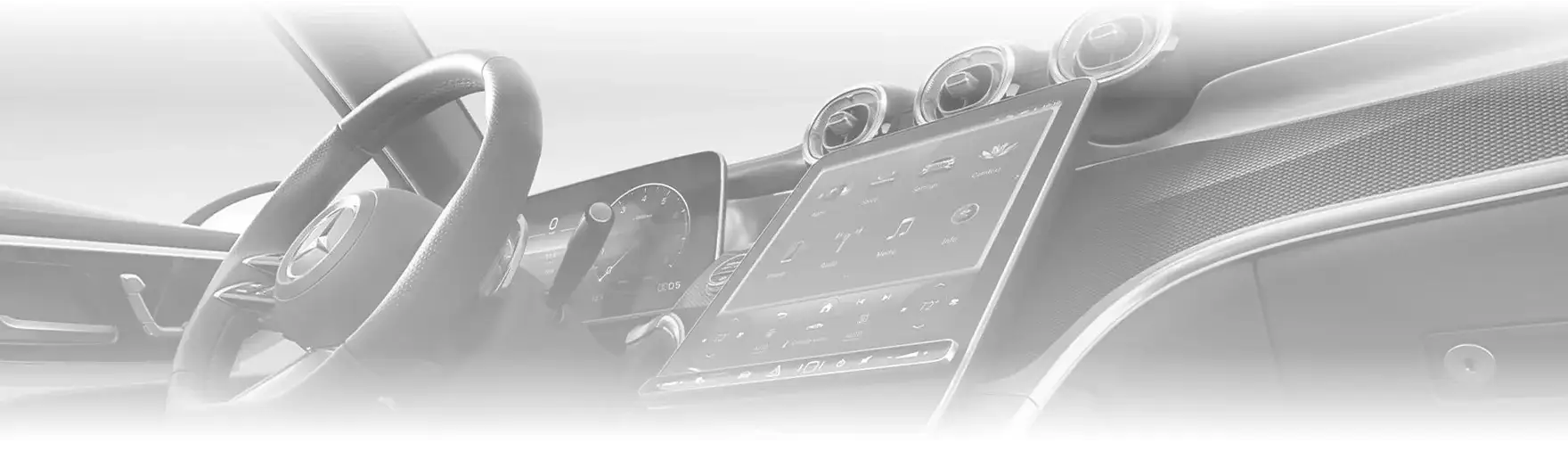 Pale, softly lit view across the GLC cockpit showing the steering wheel, digital instrument cluster, portrait touchscreen and round air vents.