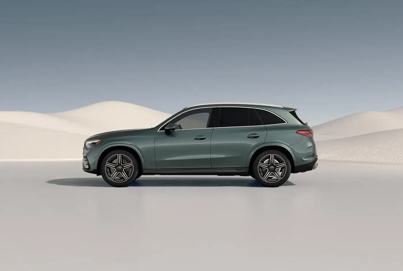 Green GLC 300 4MATIC&reg; SUV in profile against desert sand dunes.