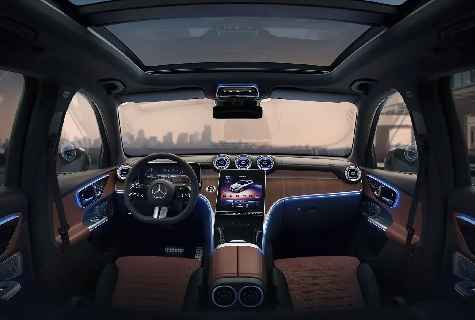 Wide view of the GLC 300 dashboard and front seats with a city skyline through the windshield.