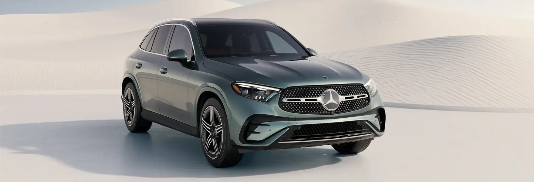Grey 2027 GLC 300 4MATIC&reg; SUV shown from a front three-quarter angle in a desert landscape.