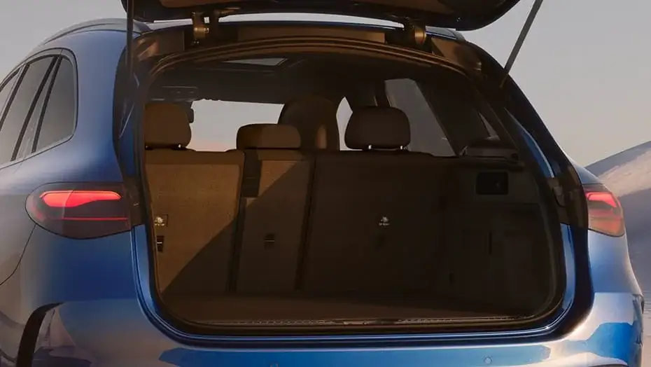 Open liftgate of a blue GLC 300 revealing the carpeted cargo area with the rear seats folded.