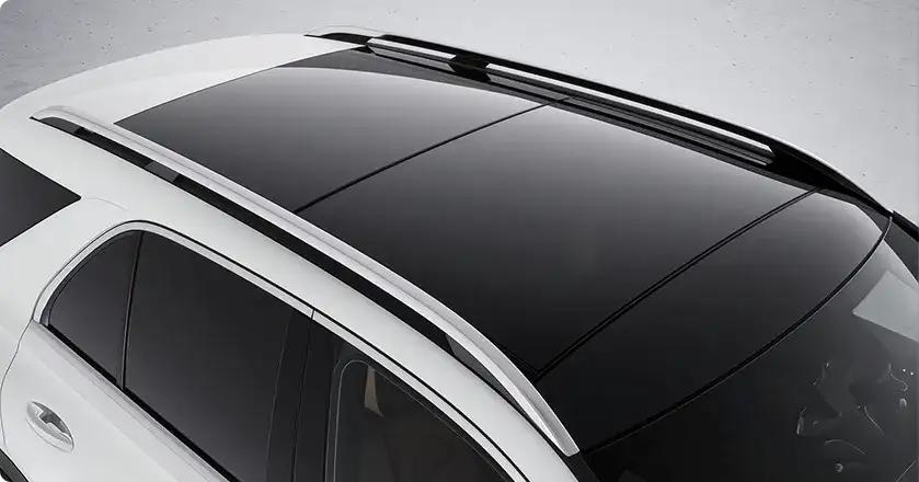 Overhead view of the black panorama roof and silver roof rails on a white GLE.
