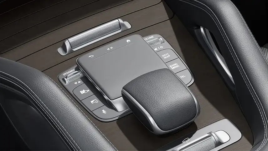 Touchpad controller with surrounding one-touch hard keys on the wood-trimmed console.