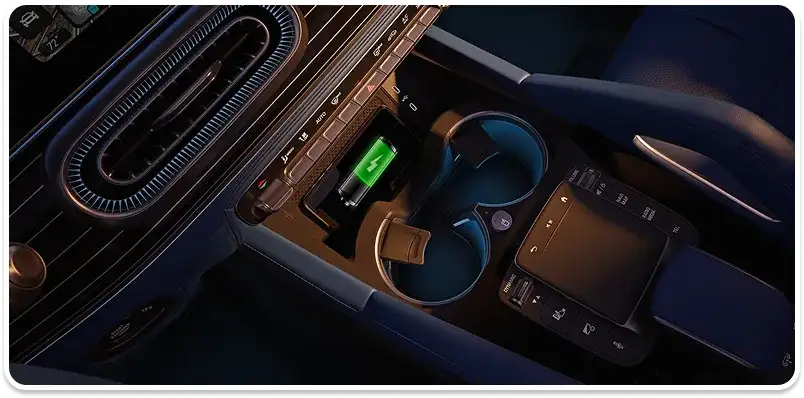 Centre console with a wireless charging pad and cupholders lit by blue ambient lighting.