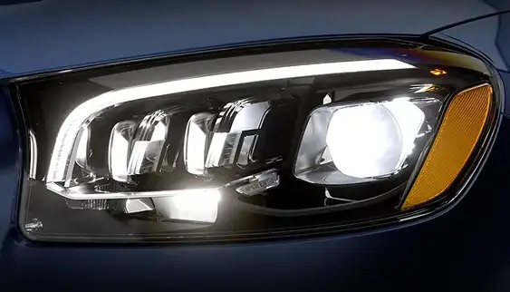 Close-up of an illuminated LED headlamp on a dark blue Mercedes-Benz GLS