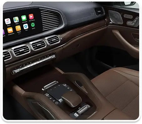 GLS cockpit with the multimedia screen showing Apple CarPlay above wood trim