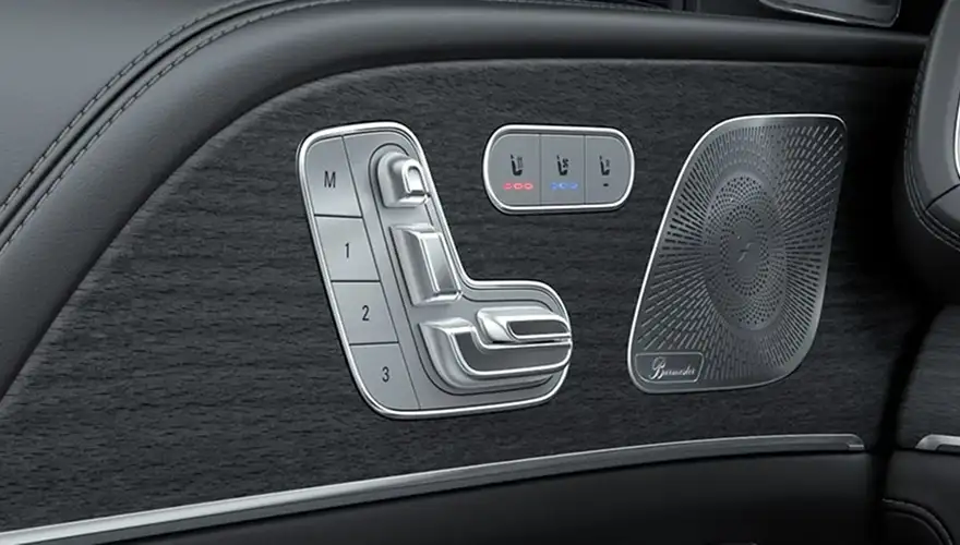 Door panel with the seat memory buttons beside a Burmester speaker grille
