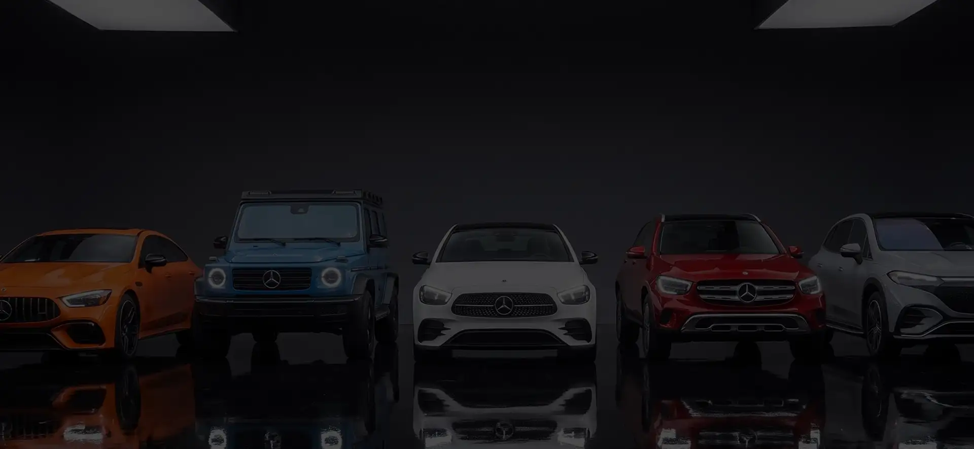 Five Mercedes-Benz models lined up facing forward in a dark studio