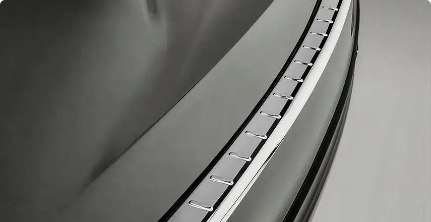 Polished metal load sill guard along the top edge of the rear bumper