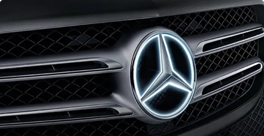 Mercedes-Benz star glowing white in the center of a dark grille
