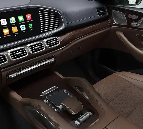 Center console with wood trim, the touchpad controller and brown leather seats