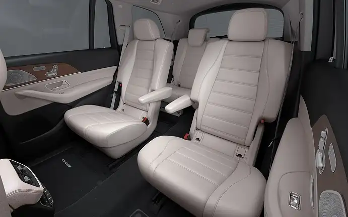 Beige leather second- and third-row seats seen through the open side of the cabin