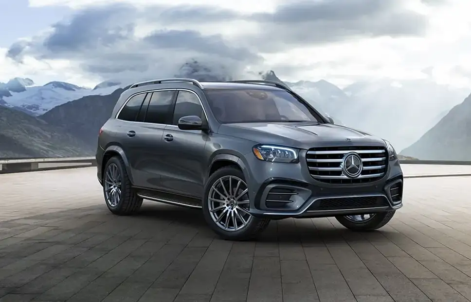 Gray Mercedes-Benz GLS on a paved plaza with mountains rising behind