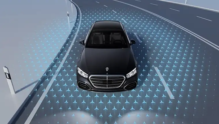 Overhead view of a black S-Class on a road with a blue sensor field illustrated around it