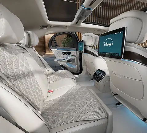 Rear cabin of the S-Class with cream quilted seats and a rear entertainment screen
