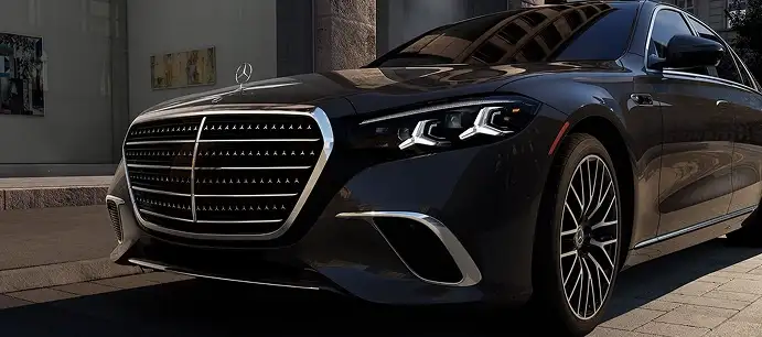 Front three-quarter view of a dark blue S-Class in a courtyard