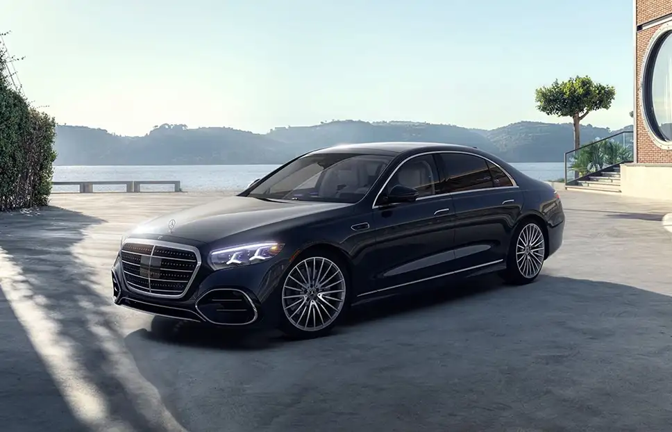 Dark blue Mercedes-Benz S-Class parked beside a waterfront terrace