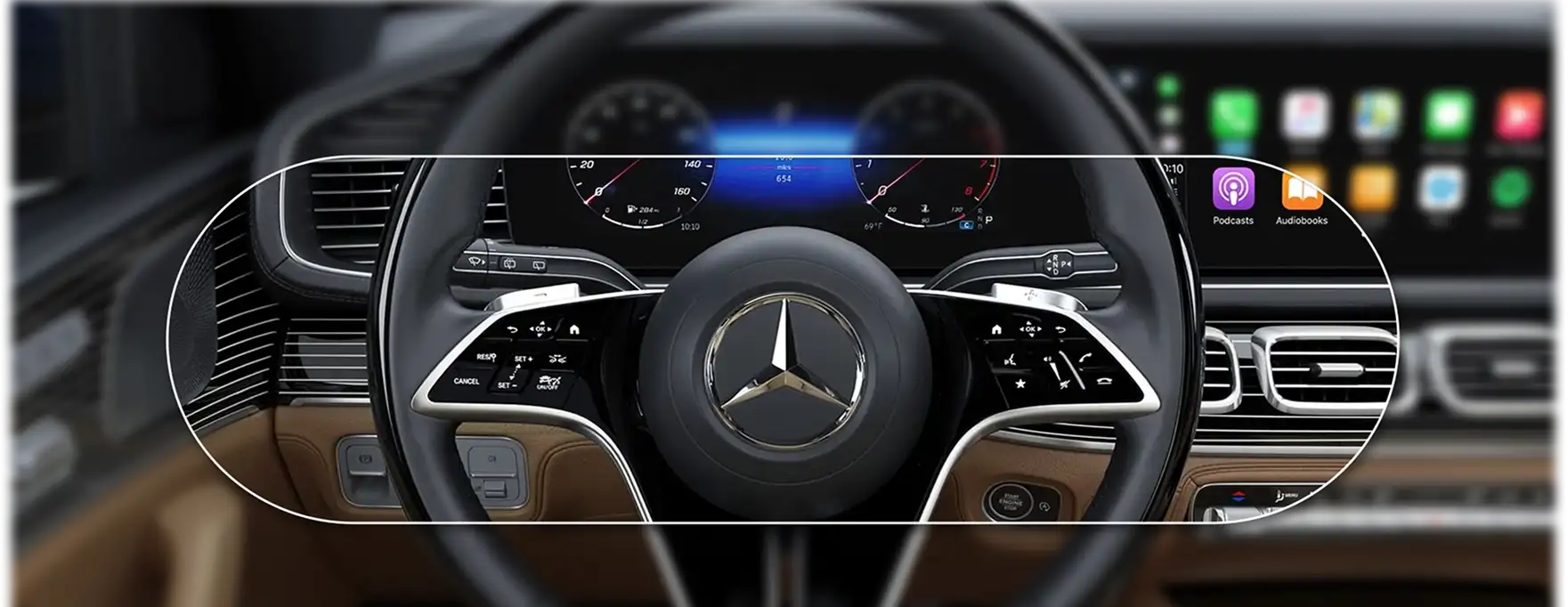 GLS cockpit with the steering wheel and widescreen displays in a dark, tan-trimmed cabin