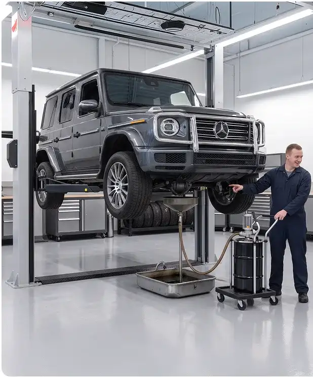 Technician explaining differential fluid service to a customer beside a grey Mercedes-Benz G-Class raised on a lift